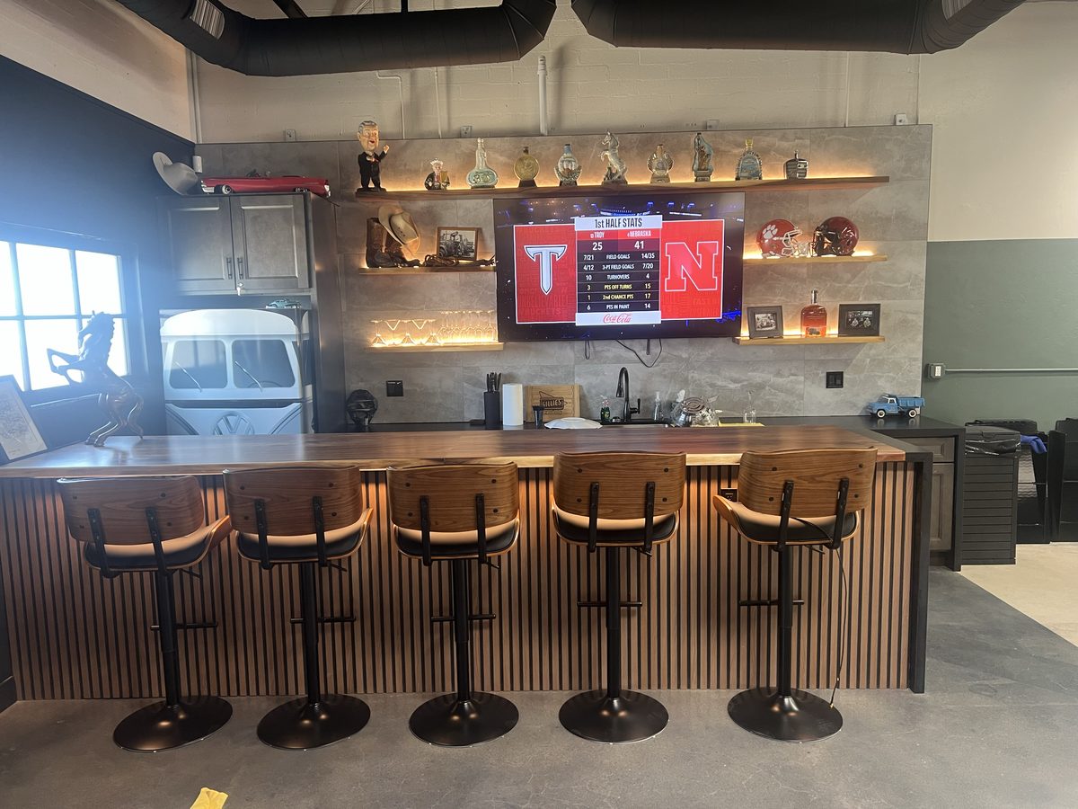 The bar area with stools and big screen