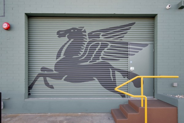 Pegasus mural on the roll-up door — Gillie's Auto Lounge