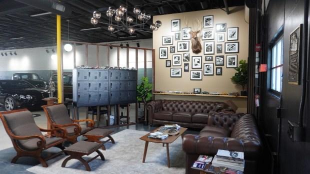 The lounge at Gillie's with a diecast car collection and a wall of black-and-white hood-ornament photos